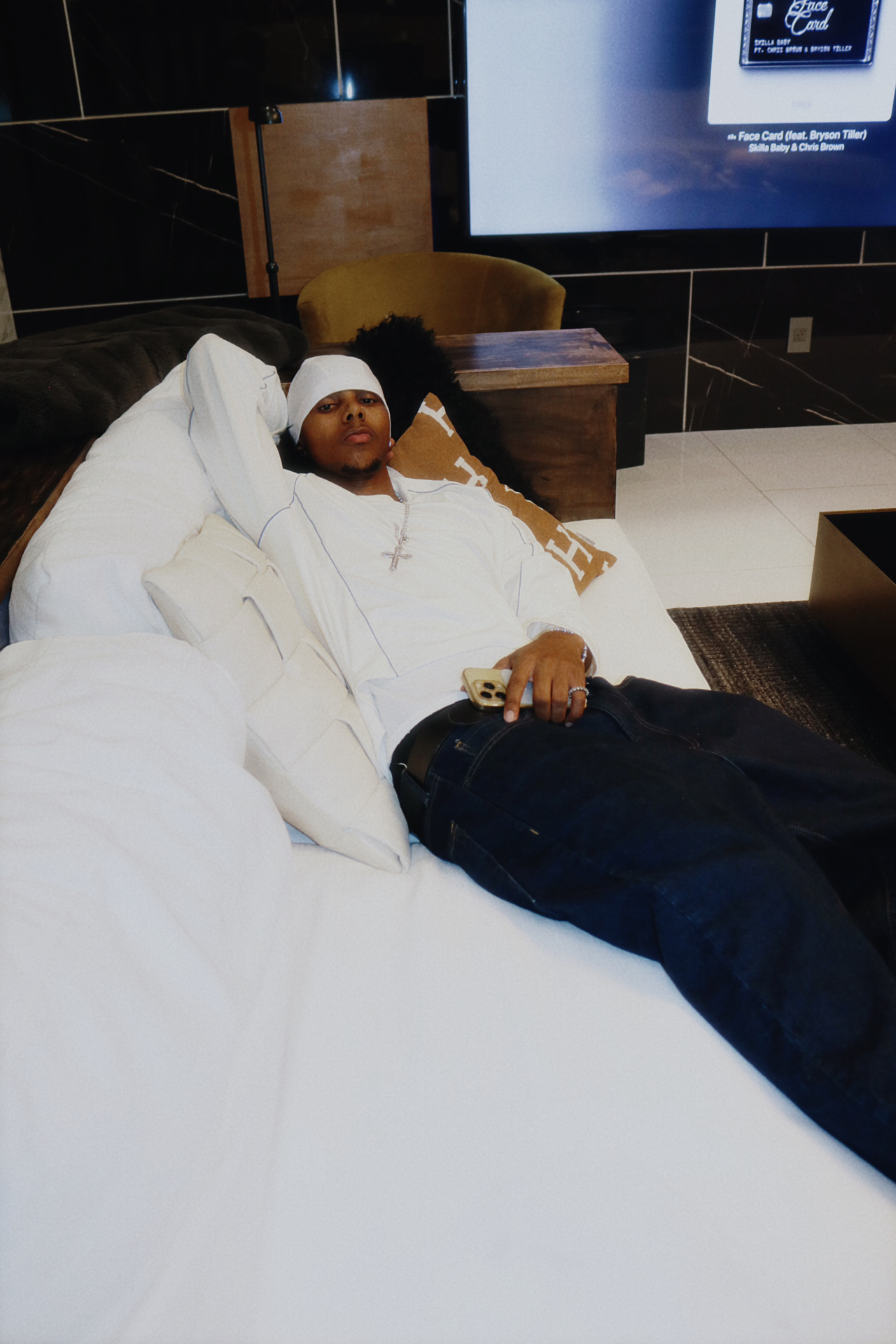 Saint Tailor reclining in a white lounge