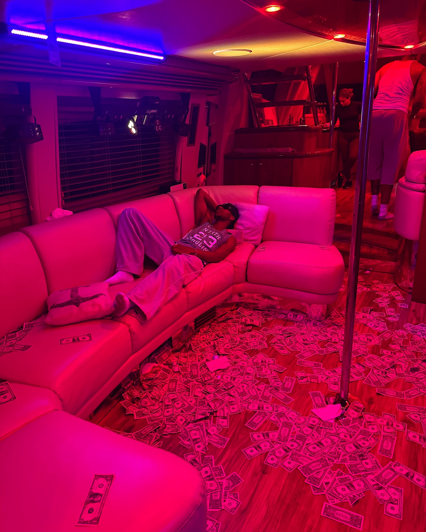 Saint Tailor reclining in a red-lit room